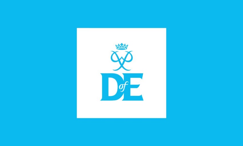 Image shows the DofE logo against a bright light blue background. It has two main elements – the Founder’s personal cypher and the letters DofE